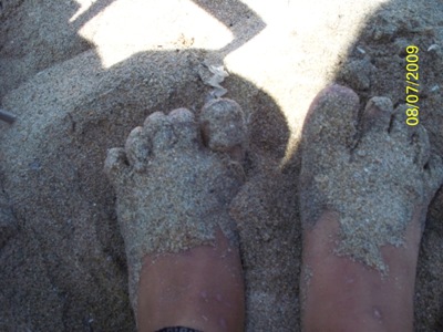 photo of girl's feet in white sand